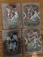 Four Select Die Cut NFL football cards in protective sleeves showing players Travis Kelce, Tristan Wirfs, and two others.