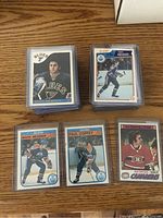 Face-up cards of Doug Gilmour, Mark Messier, Paul Coffey and Ken Dryden displayed on wood surface