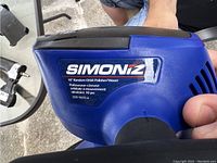 Close-up of Simoniz polisher showing brand logo, model information, and blue plastic body.