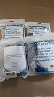 Four sealed bunion care kits packed in clear plastic bags showing branding for fast pain relief and one size fits most.