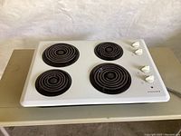 Top view of Admiral 4-burner electric cooktop showing four coil burners and four control knobs.