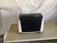 Front view of white and black Royal Sovereign dehumidifier placed on a table.