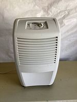 Front view of the white Whirlpool dehumidifier showing the ventilation grille and overall condition.