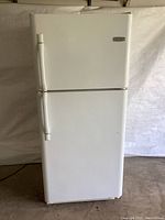 Front view of the white Frigidaire refrigerator, showing top freezer and bottom fridge doors closed.