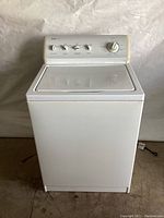 Front view of white Kenmore washing machine showing full body with closed lid and control panel.