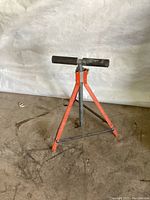 Saw extension stand viewed full height with tripod legs and rollers on top.