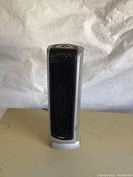 Full front view showing the tower heater design, black mesh front panel, silver sides, and base with Lasko branding.