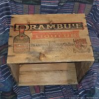 Top front view of the wooden crate showing Drambuie branding and some wear.