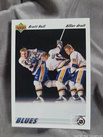 Front of the Bret Hull hockey card showing three images of Hull in St. Louis Blues uniform and logos.
