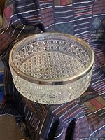 Clear crystal bowl with patterned hobnail texture and a silvered rim shown on a colorful textile background. The bowl measures about 12 inches diameter and 3 inches tall.