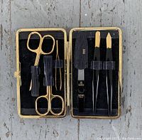 Open Birks Solingen manicure set showing gold-tone manicure tools inside black velvet-lined case with elastic bands.