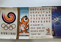 Four vintage Seoul 1988 Olympics posters laid out side by side, showing various mascot and logo designs.