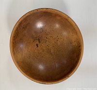 Top view of the teak bowl showing ring-shaped discolorations, scratches, and wear on the interior surface.