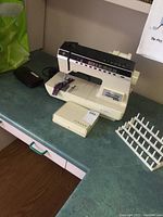 Singer Athena 2000 sewing machine with foot pedal and thread rack on counter.