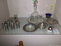 Full lot showing decanter, silver plate dishes, tray, and shot glasses