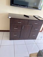 Front view of the dark wood six drawer cabinet with central door storage, showing overall structure.