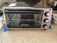 Front view of Black+Decker toaster oven on countertop showing overall condition.