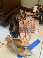 Three pairs of women's shoes arranged on the floor showing different colors and styles.