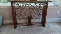 Front view of console table showing wood top and metal Tree of Life base