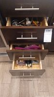 Photo showing three open kitchen drawers filled with assorted cooking utensils and tools.