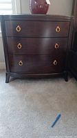Front view of one nightstand showing three drawers and ring pulls.