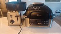 Ninja Foodi Grill and Cuisinart toaster side by side on counter