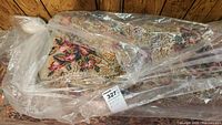 Rolled and plastic-wrapped view of folded rug against wood paneling