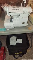 Front view of Baby Lock Evolution machine on table with black bag below