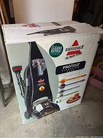 Box front showing Bissell ProHeat ClearView Plus upright deep carpet cleaner with hose and attachments.