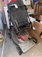 Front and side view of the Craftsman lawn mower with grass collection bag attached, showing the overall condition and dirt accumulation.