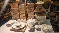 Full display of Churchill Briar Rose English china pieces including boxed mugs, plates, bowls, and serving pieces arranged on table.