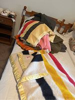 Hudson Bay Point Blanket and other vintage wool blankets stacked on a bed.