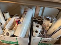Two cardboard boxes filled with multiple rolls of interfacing and stabilizer