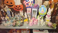 Overview of tabletop display showing assorted Easter-themed decor: blow molds, planters, boxed Cottontale Cottages sets, figurines