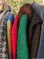 Overview of rack showing multiple vintage garments including coats, jackets and sweaters
