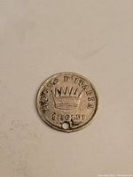 Reverse side of coin showing crown and denomination 5 Soldi with inscription 'REGNO D'ITALIA', hole visible near edge.