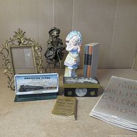Wide shot of all assorted vintage items showing figurines, frame, books, model train display, decorative box, and calendar
