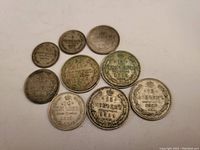 Overhead view of nine Tsarist Russian silver coins arranged on white background