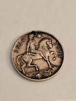 Obverse side of the miniature WWI silver medal depicting a horseman and the years 1914 and 1918
