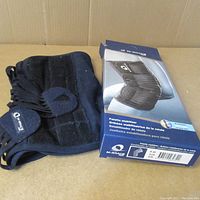 Photo of M-brace Patella Stabilizer Knee Brace with original blue box showing branding and product image.