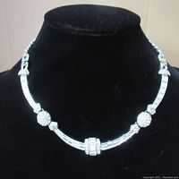 Full view of the vintage rhinestone necklace, showing the design with baguette and round stones on a black display bust.