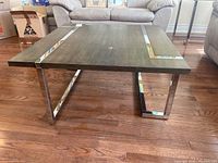 Full front view of coffee table with composite wood top and metal inlay legs