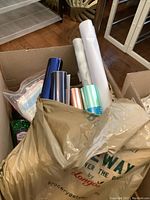 Box with rolled vinyls in various colors along with foil rolls and craft supplies