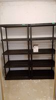 Two black plastic 5-tier shelving units side by side against basement wall on concrete floor.