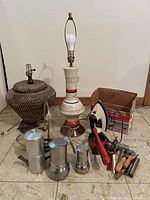 Photo showing entire lot with 2 lamp bases, 3 espresso makers, small iron, manual coffee grinder, wooden and metal utensils
