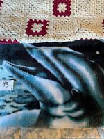 Close-up view of the blue dolphin design fabric blanket showing detailed dolphin image and fabric texture.