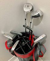 Top view showing 7 golf clubs inside Wilson branded golf bag, details of club heads visible with Northwestern Bob Murphy Classic branding