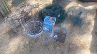 Overview of multiple metal wreath forms, wire decorative cages, plant holders and the book on wreath making spread on the ground outdoors.