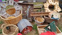 Photo of all items showing bird houses, baskets, wooden decorative pieces on grass