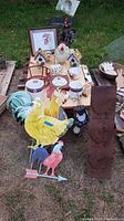 Overview of assortment showing multiple rooster-themed items including birdhouses, yard art, figurines and kitchen decor